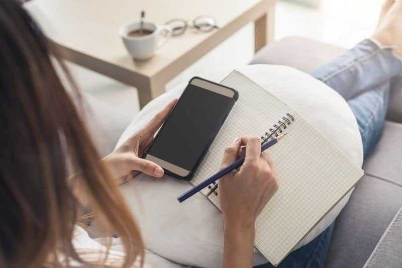 woman using cell phone to shop for a new mobile carrier